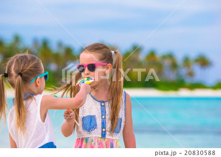 Two little girls eating bright lollipops on the 20830588