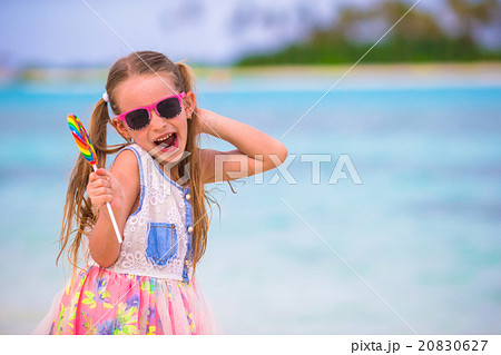 Adorable little girl have fun with lollipop on the Adorable little girl have fun with lollipop on the 20830627