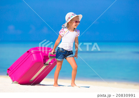 Little adorable girl with big suitcase on tropical Little adorable girl with big suitcase on tropical 20830991