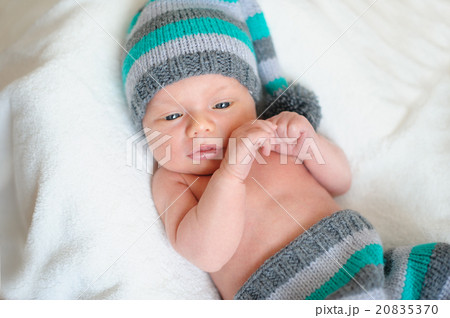 little baby boy in knitted hat lying on the bed 20835370