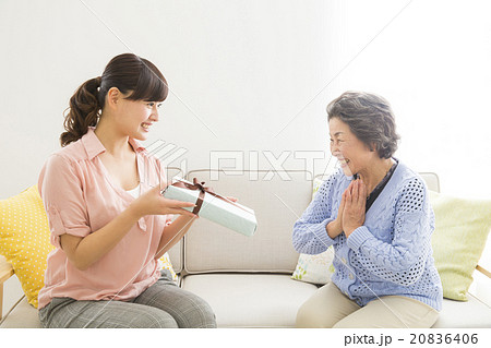 シニア女性にプレゼントを渡す若い女性 20836406