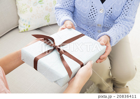 シニア女性にプレゼントを渡す若い女性の写真素材 6411