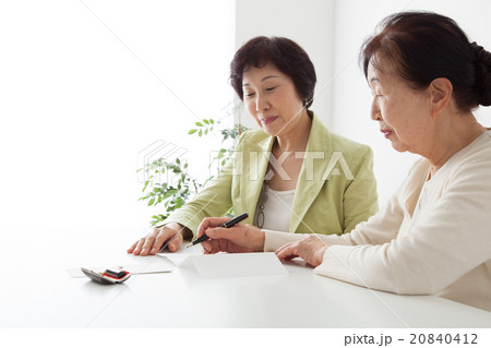 書類を記入するシニア女性とミドル女性 書類を記入するシニア女性とミドル女性 20840412
