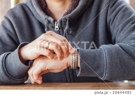 Woman checks the time on a wrist watch 20844495