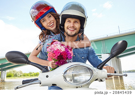 Cheerful couple riding vintage scooter Cheerful couple riding vintage scooter 20845439