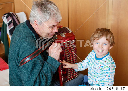 Little kid boy and grandfather playing music 20846117