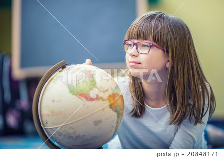 Pretty little student girl studying geography with Pretty little student girl studying geography with 20848171