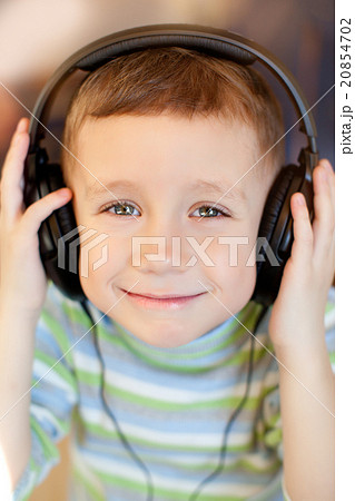 the child listens to music via earphones 20854702