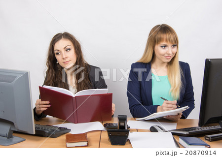 Two business women working with one rival desktop 20870914