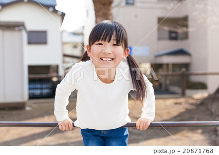 鉄棒で遊ぶ小学生の女の子 20871768