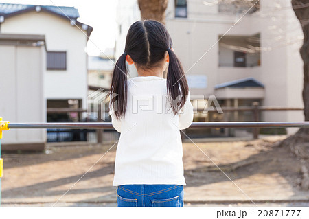 鉄棒で遊ぶ小学生の女の子の写真素材