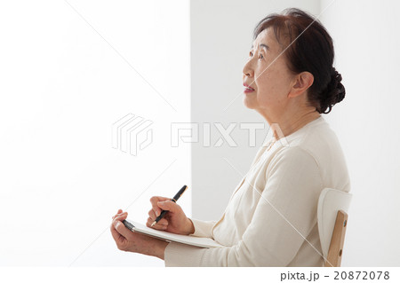 椅子に座ってノートを書くシニア女性 自分史 椅子に座ってノートを書くシニア女性 自分史 20872078