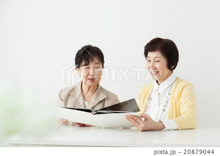 アルバムを見つめるシニア女性とミドル女性　家族写真　思い出 20879044