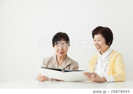 アルバムを見つめるシニア女性とミドル女性　家族写真　思い出 20879045