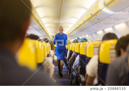 Stewardess and passengers on commercial airplane. 20886530