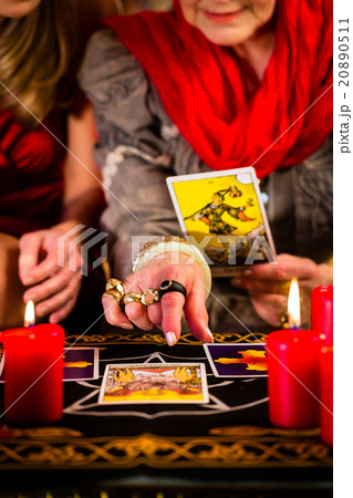 Fortuneteller laying Tarot cards with client Fortuneteller laying Tarot cards with client 20890511