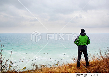 Man in green windcheater look at sea far horizon. Man in green windcheater look at sea far horizon. 20912002