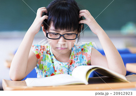Depressed little girl studing in the classroom Depressed little girl studing in the classroom 20912923