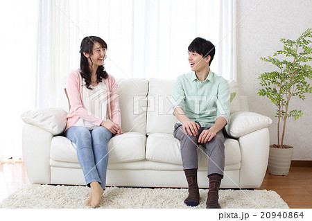 ソファーに座るカップルの写真素材