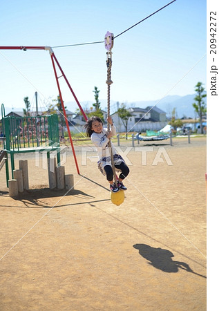 ターザンロープで遊ぶ少女の写真素材