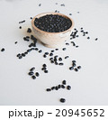 Black beans in a wooden bowl, scattering near 20945652