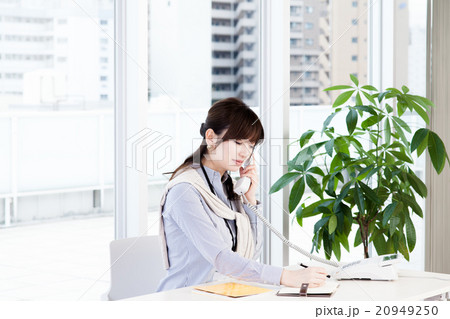 電話連絡をするビジネス女性　デスクワーク　ビジネスカジュアル 20949250