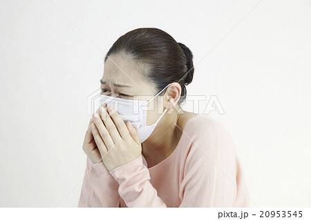 くしゃみをする女性40代 マスク着用の写真素材