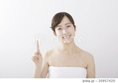 若い女性　指し示す　笑顔　上半身　バスタオル　カメラ目線　白バック　コピースペース 20957420