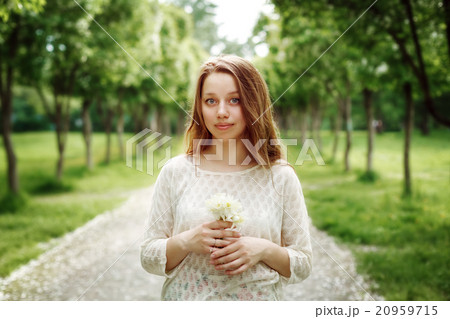 Young Woman Holding Flowers Outdoors 20959715