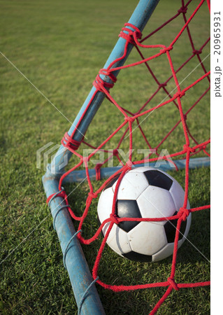 Portrait of football inside red goal net 20965931