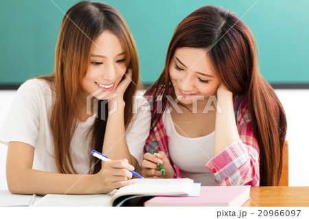 happy teenage students girls watching the books in classroom happy teenage students girls watching the books in classroom 20966097