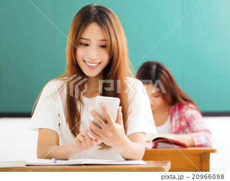 young female student using smart phone in classroom young female student using smart phone in classroom 20966098