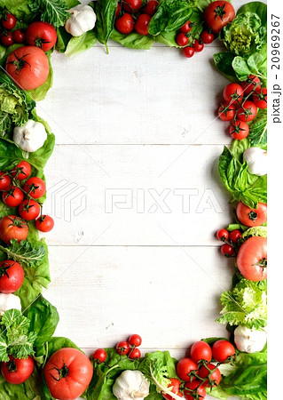トマトとにんにくとバジルのフレーム 白木材背景の写真素材