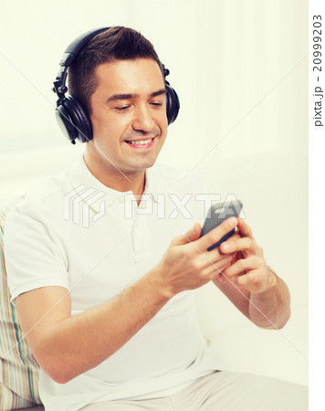 happy man with smartphone and headphones happy man with smartphone and headphones 20999203