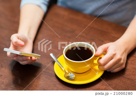 close up of woman with smartphone and coffee close up of woman with smartphone and coffee 21000280