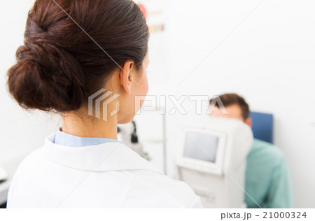 close up of optician and patient at eye clinic 21000324