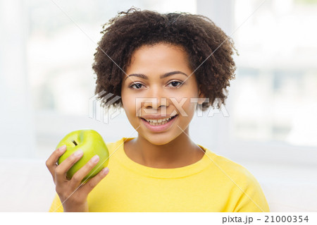 happy african american woman with green apple 21000354