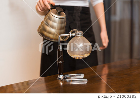 close up of woman with siphon coffee maker and pot 21000385