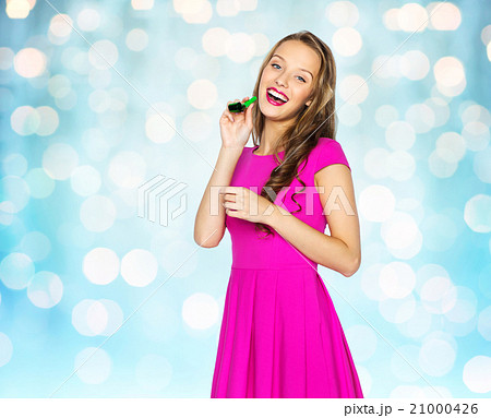 happy young woman or teen girl with party horn happy young woman or teen girl with party horn 21000426