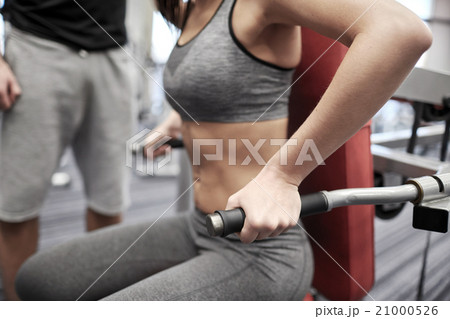 close up of woman flexing muscles on gym machine 21000526