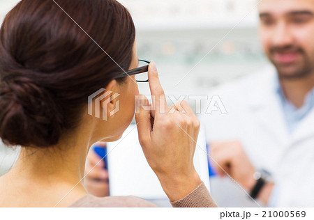 close up of woman choosing glasses at optics store 21000569
