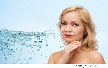 smiling woman with bare shoulders touching face smiling woman with bare shoulders touching face 21000696