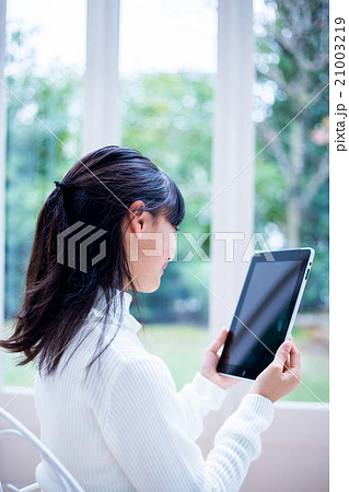 タブレットPCを使っている女の子　女性　中学生　ハウススタジオ　家　タブレット端末 21003219