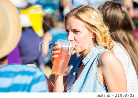 Young blond woman with beer at summer music 21003702
