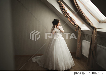 Luxury bride in white dress posing while preparing 21007507