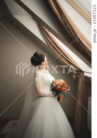 Luxury bride in white dress posing while preparing 21007523