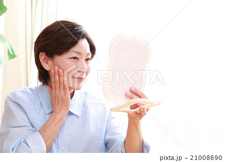 お肌をチェックする美しい50代女性の写真素材