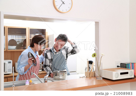 仲良くキッチンに立つ50代夫婦 21008983