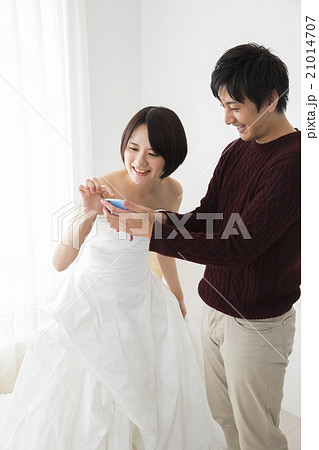 ブライダルイメージ　ドレスを選ぶ若いカップル 21014707