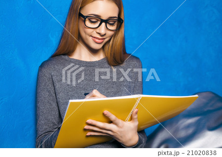 Cute girl against blue wall 21020838